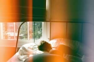 man sleeping in bed with film burn effect