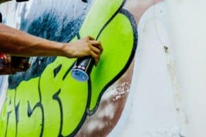 someone spray painting a wall